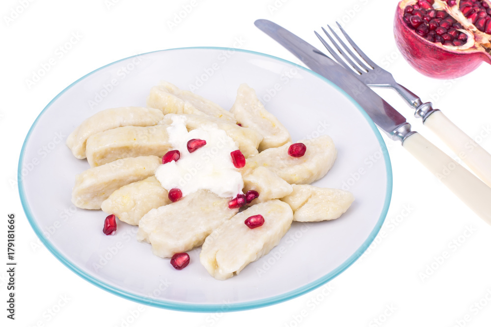 Dumplings from cottage cheese with yoghurt and pomegranate seeds