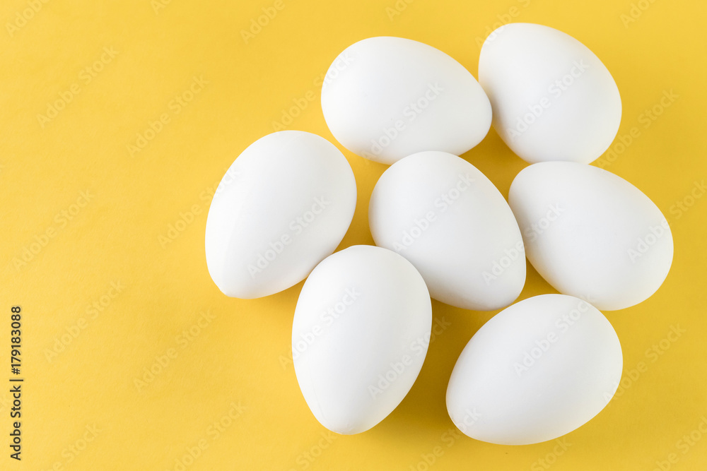 Seven White Hen Eggs Isolated On Yellow Background Seven White Hen Eggs Isolated On Yellow Background