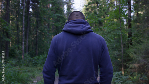 Photos Rear view of male hiker standing in forest