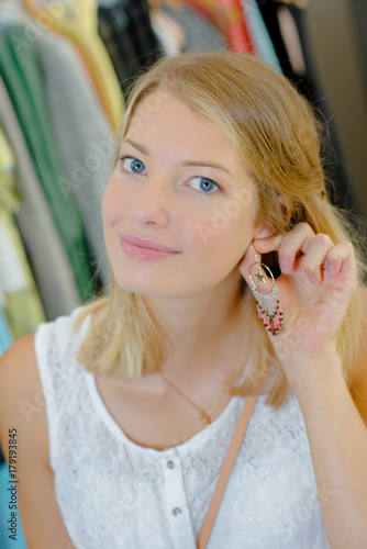 girl putting on earrings
