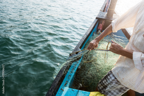 fisherman pulling his net out of the water