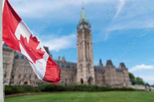 Canadian flag waving with Parliament Buildings hill in the background Ottawa,Ontario, Canada