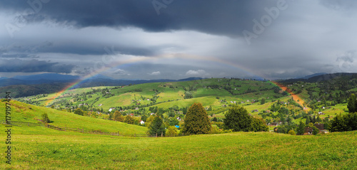 Fototapeta Naklejka Na Ścianę i Meble -  Rainbow over the villiage at the Carpatian mountains
