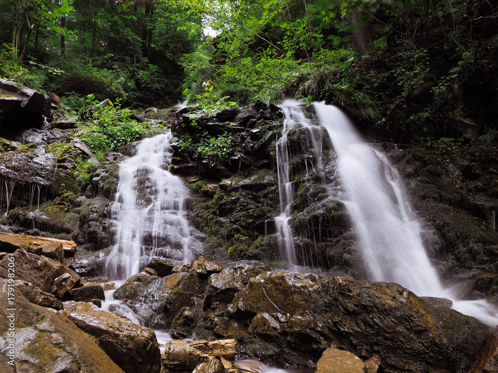 Obraz premium Waterfall at the carpatian mountains green forest
