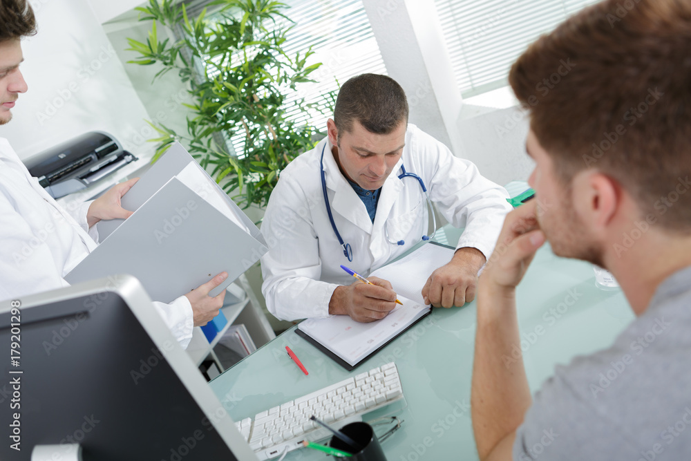 doctor consulting with young man doctor consulting with young man