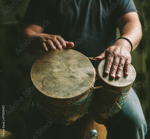 A man playing a set of bongos photo