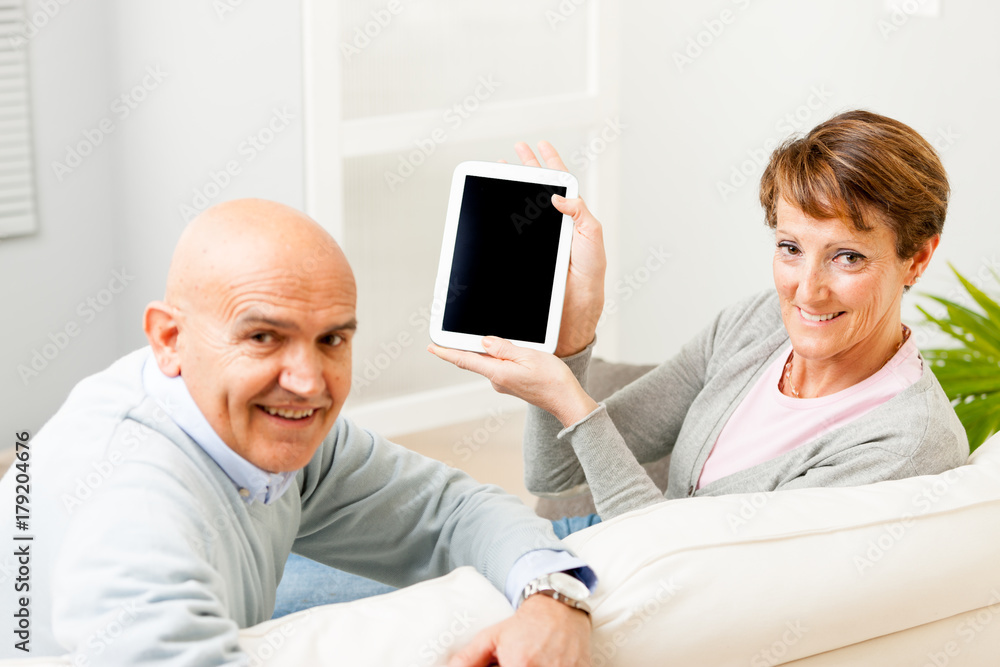 Obraz premium Mature couple displaying a blank tablet-pc