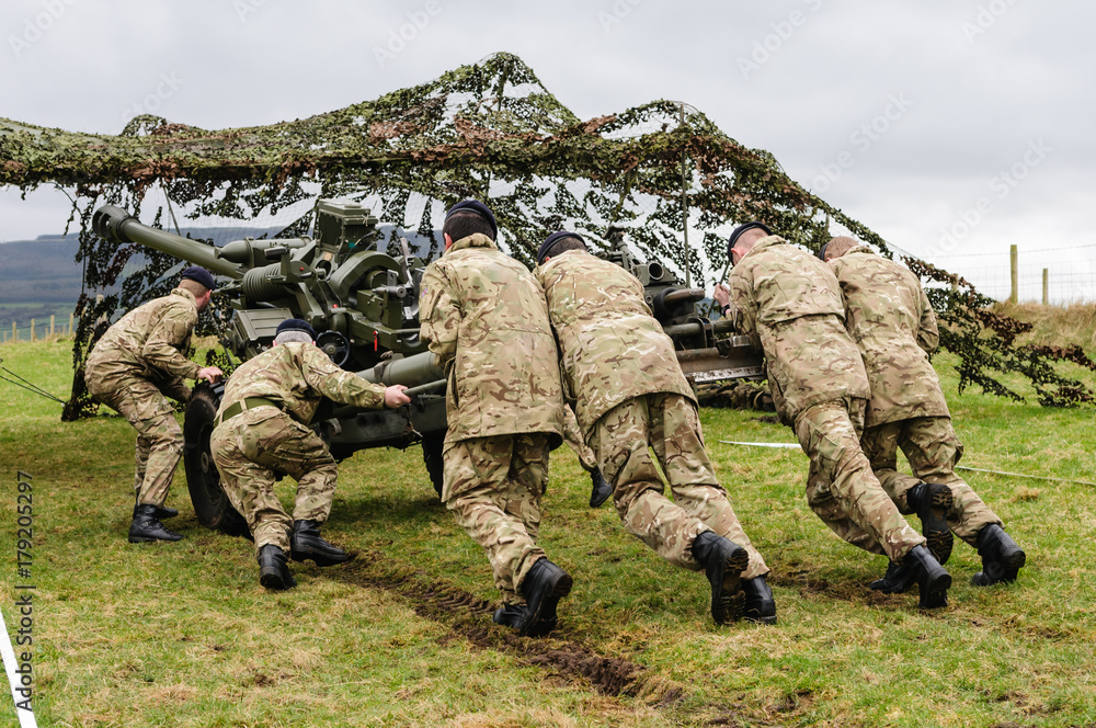 Soldiers from the Royal Artillery Corp push a 105mm Light Gun into