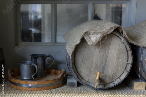 Close-up of beer barrels and pewter mugs covered with hessian cloth