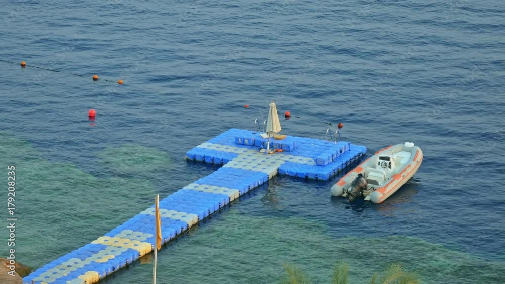Floating jetty dock over coral reef at the tropical sea resort