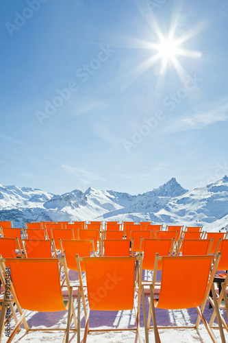 Brightly coloured sun loungers on the slopes of Courchevel 1850 ski resort in the Three Valleys, Les Trois Vallees, Savoie, French Alps, France