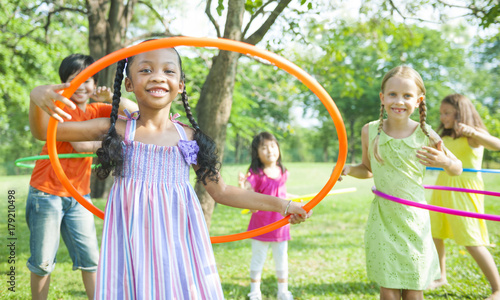 Cute diverse kids playing with hula hoops
