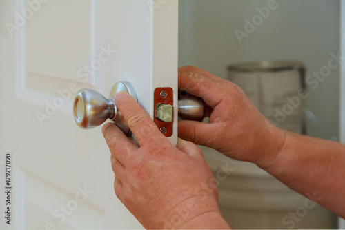 Tablou pe pânză Closeup of a professional locksmith installing or repairing a new deadbolt lock