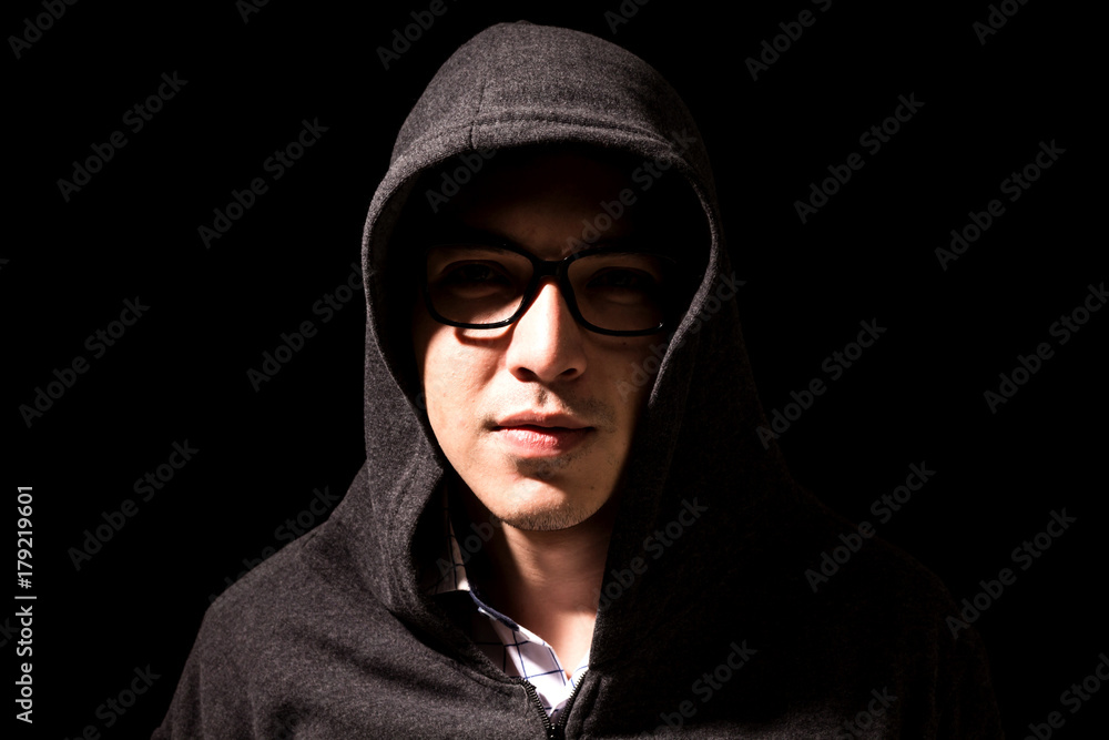 Hacker in a hood on dark background Hacker in a hood on dark background