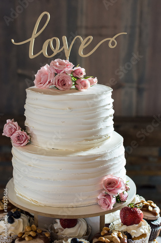 Εκτύπωση καμβά Rustic ruffled wedding cake with love topper and fresh pink roses