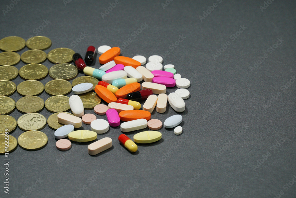 Various medicine pills and tablets with a malaysian coins on isolated black background. Various medicine pills and tablets with a malaysian coins on isolated black background.