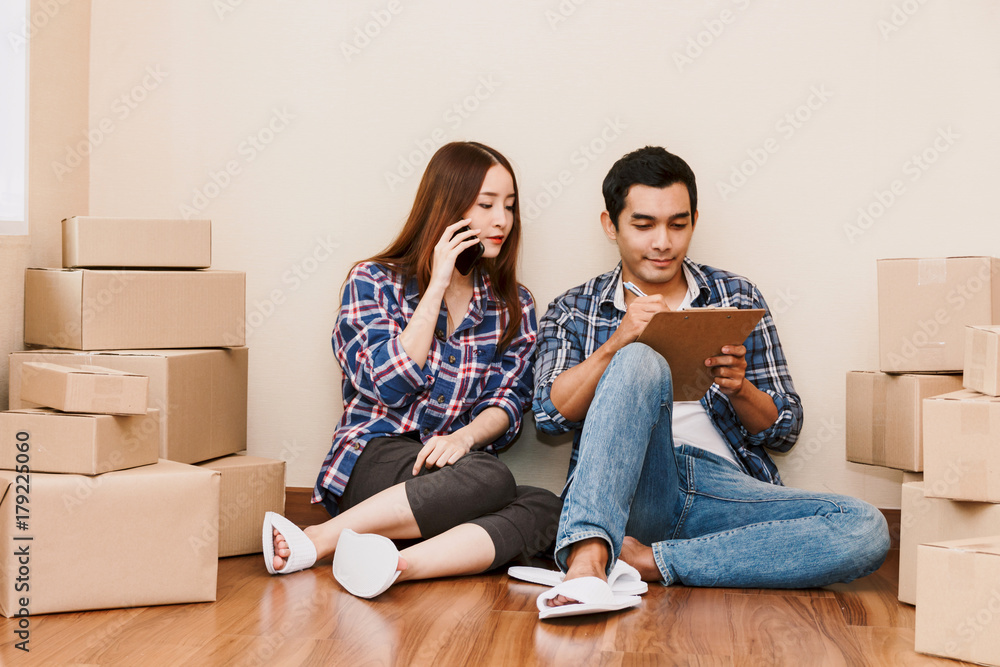 Young couple checklist with cardboard box at home - Business online and delivery concept Young couple checklist with cardboard box at home - Business online and delivery concept