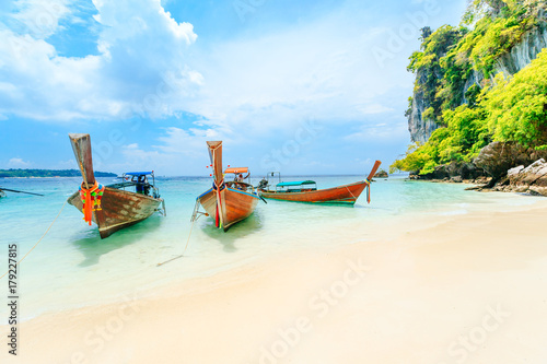 Longtale boat on the white beach at Phuket, Thailand. Phuket is a popular destination famous for its beaches.