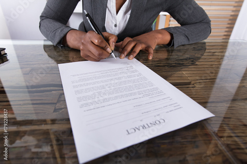Businesswoman Holding Pen To Sign On Contract Paper