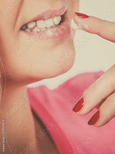 Woman applies lip balm cream to her lips