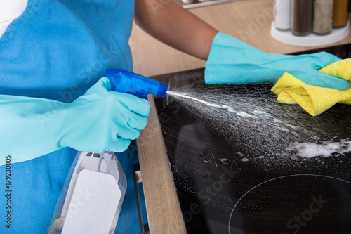 Bild auf Leinwand Person Hands Cleaning Induction Stove