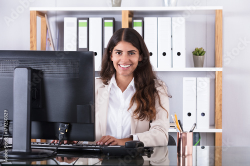 Smiling Businesswoman Typing On Keyboard