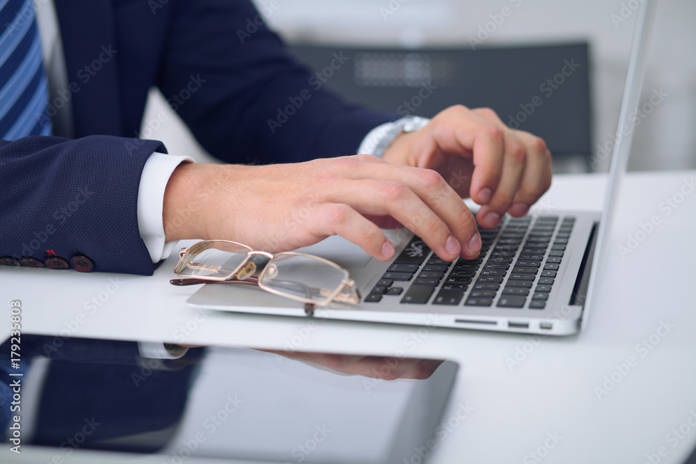 Businessman working by typing on laptop computer. Man's hands on notebook or business person at workplace. Employment or start-up concept Businessman working by typing on laptop computer. Man's hands on notebook or business person at workplace. Employment or start-up concept