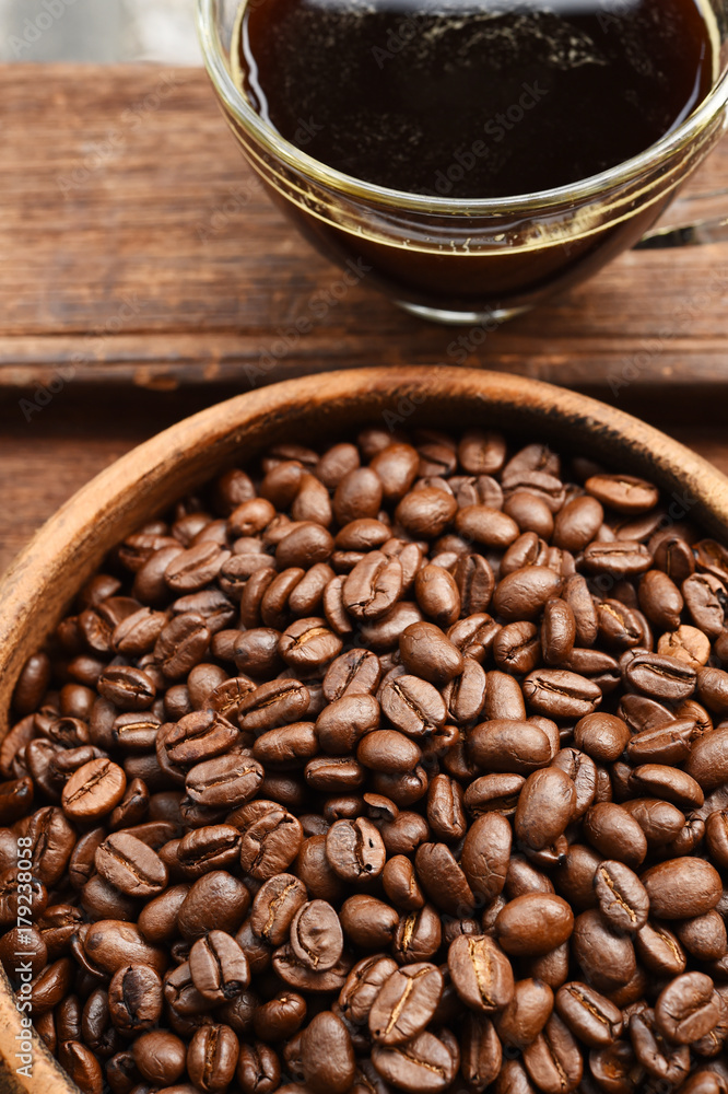 cup of coffee and coffee beans in wooden bowl cup of coffee and coffee beans in wooden bowl