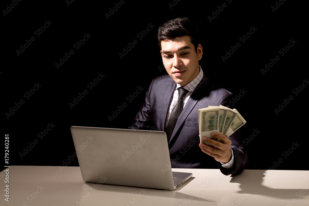 Businessman holding Dollars on black background Businessman holding Dollars on black background