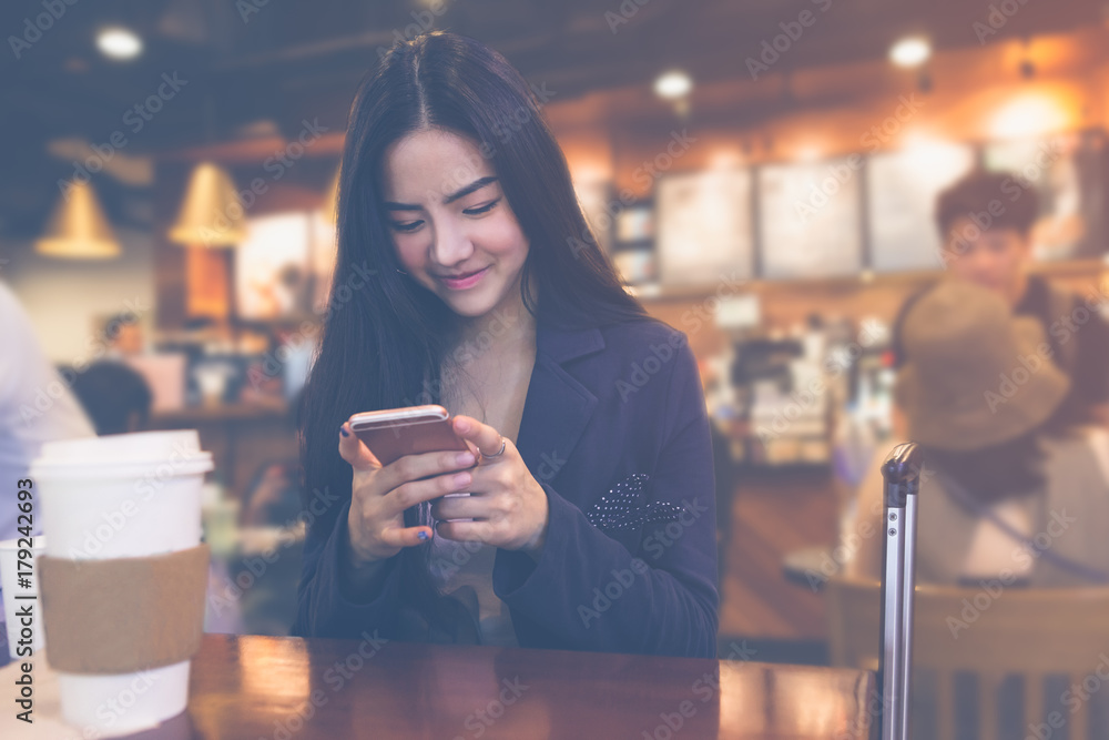 Photo businesswoman wearing suit, touching smartphone screen and smiling.