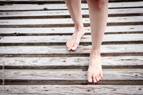 Beautiful woman legs and-feet walking on the wood bridge © PRASERT