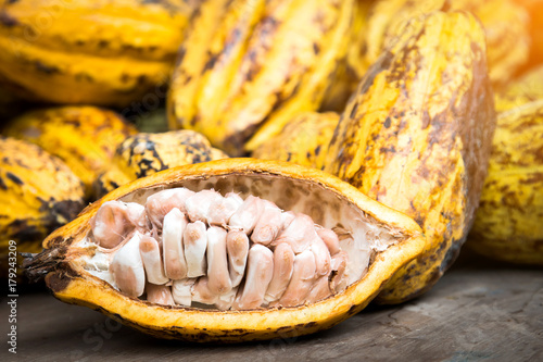 Cocoa beans and cocoa pod on a wooden surface.