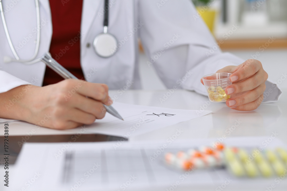 Female medicine doctor fills up prescription form to patient closeup. Panacea and life save, prescribe treatment, legal drug store, contraception concept Female medicine doctor fills up prescription form to patient closeup. Panacea and life save, prescribe treatment, legal drug store, contraception concept