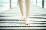 Beautiful woman legs and-feet walking on the wood bridge