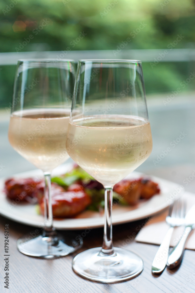 Two glasses of delicious cooled white wine with snack in restaurant.. Two glasses of delicious cooled white wine with snack in restaurant..