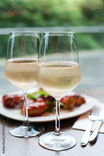 Two glasses of delicious cooled white wine with snack in restaurant..
