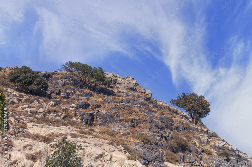 Naklejka premium Blue cloudy sky and part of top mountain cliff view