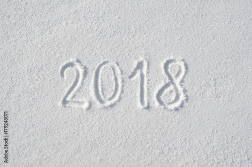 2018 text letters handwritten on flat snow surface. New year holiday seasonal postcard, greeting card.