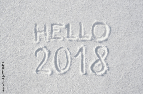 Hello 2018 text letters handwritten on flat snow surface. New year holiday seasonal postcard, greeting card.