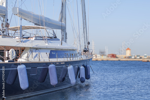 Boat luxury side docked on marine harbor port with clean sky background