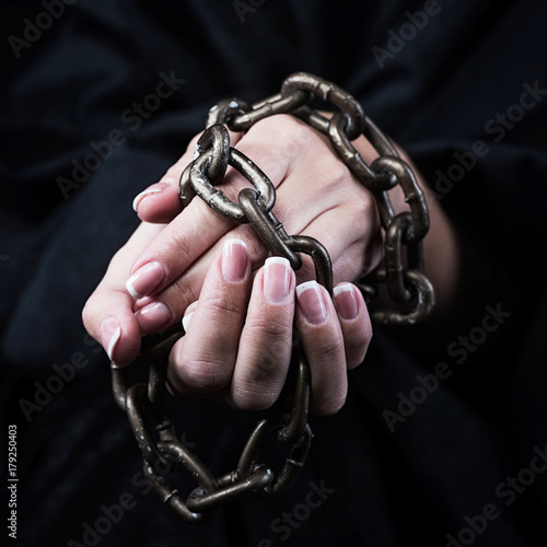 Hands in chains. Woman prisoner concept.