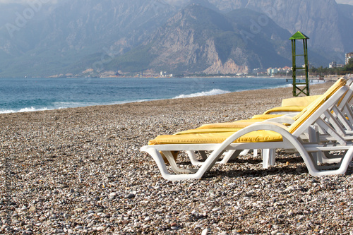 Empty beach chairs on the beach near blue water, Kemer, Turkey, Mediterranean sea.