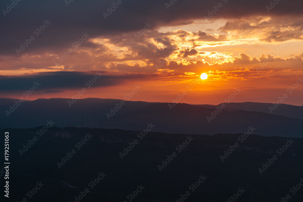 Dramatic sunset summer landscape in mountains with sun at dawn
