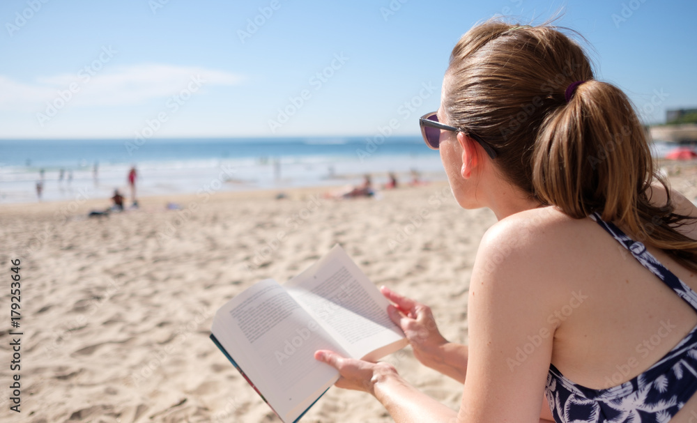Frau mit Buch am Strand