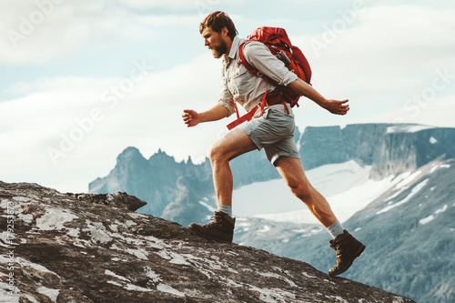 Man adventurer skyrunning in mountains with backpack Norway Travel hiking lifestyle concept active weekend summer vacations athletic person © EVERST
