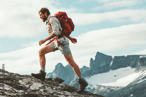 Man trail running in mountains with backpack Norway Travel hiking lifestyle concept active weekend summer vacations wild trek