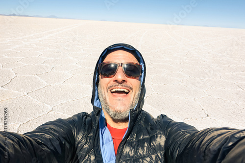 Young man solo traveler taking selfie at Salar de Uyuni saltflats in south american bolivian desert - Adventure wanderlust concept on world famous nature wonder in Bolivia - Bright afternoon tones © Mirko Vitali