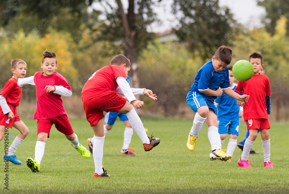 Young children players football match on soccer field Young children players football match on soccer field