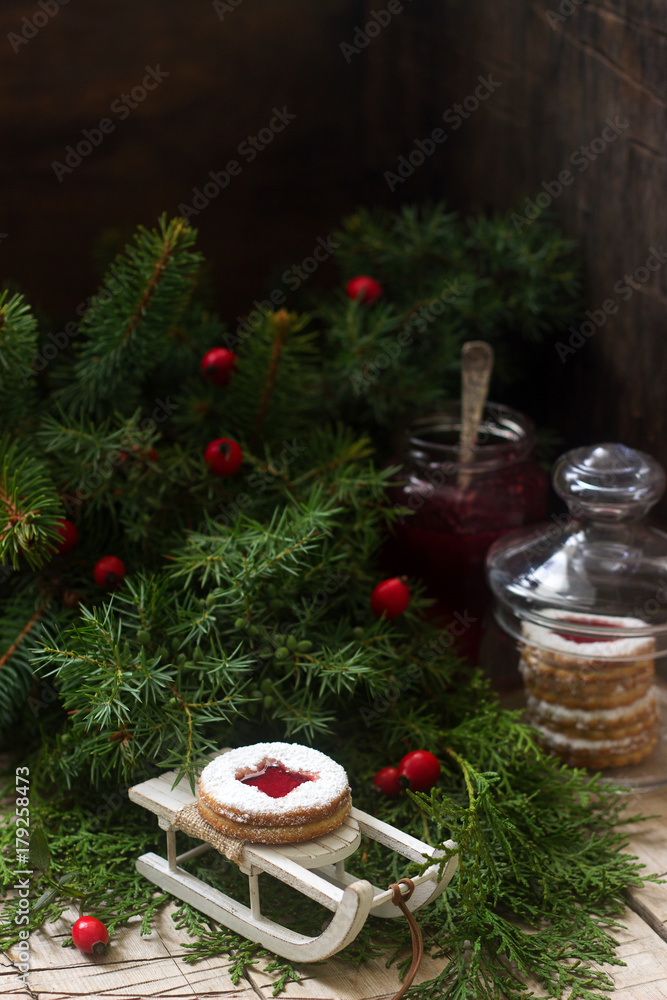 Linzer cookies in a Christmas decoration on a wooden surface. Linzer cookies in a Christmas decoration on a wooden surface.