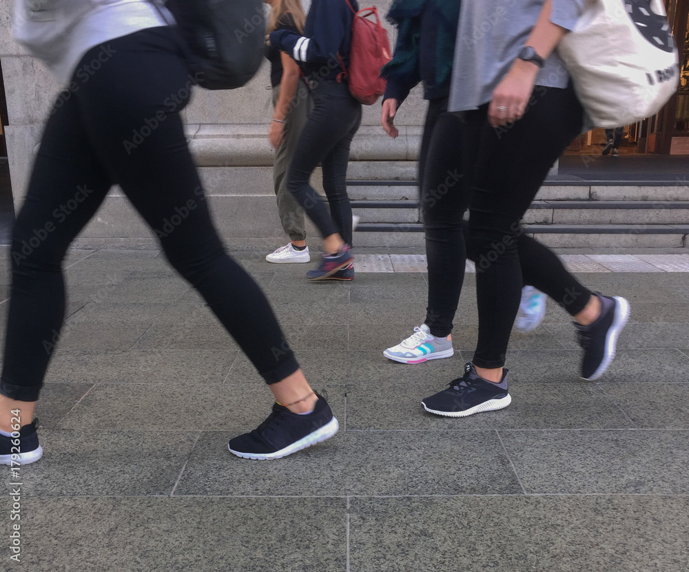 Women's legs walking on a pavement Women's legs walking on a pavement